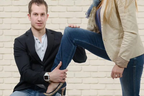 Ung kvinna sätter sin fot på sin älskare — Stockfoto