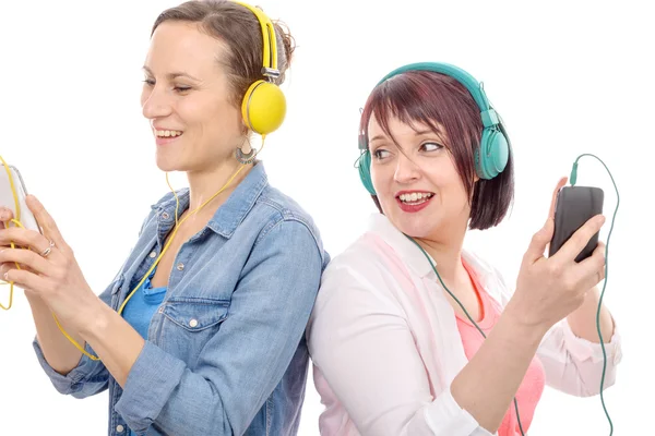 Zwei schöne Frauen hören Musik mit Kopfhörern — Stockfoto