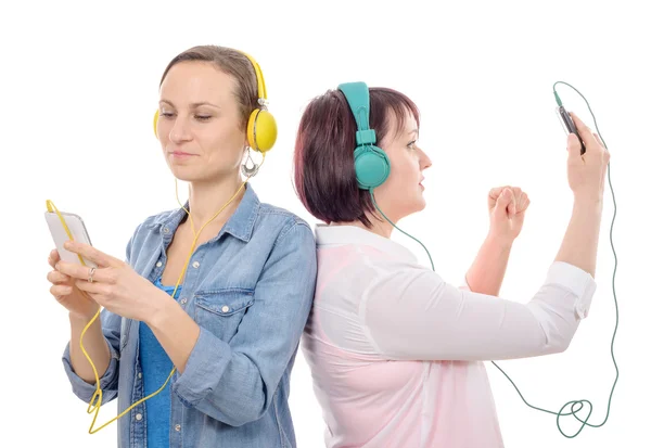 Dos hermosas mujeres escuchando música con smartphone —  Fotos de Stock