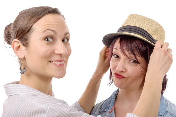 Šťastné ženy přátelé se snaží klobouky — Stock fotografie