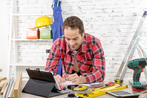 Smiling young man using the tablet for DIY — Stock Photo, Image