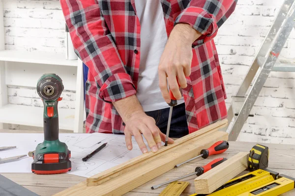 Close up van een timmerman die geschroefd op een houten plank — Stockfoto