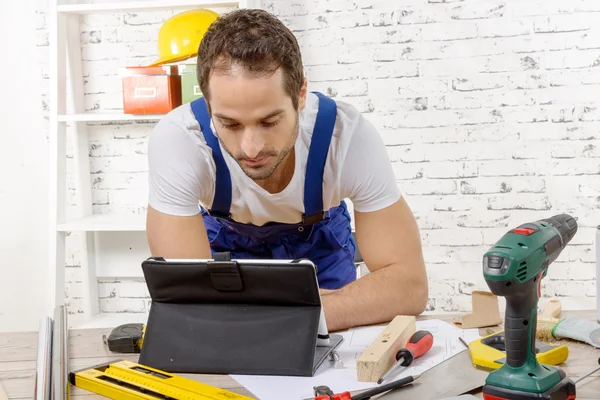 Attractive young man using the tablet for DIY — Stock Photo, Image