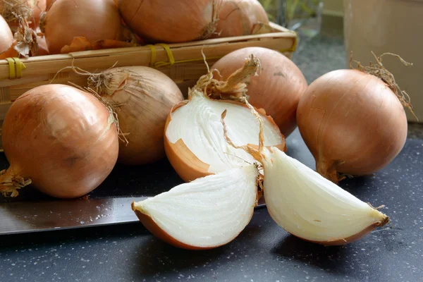 Sliced onions with a basket of onions — Stock Photo, Image