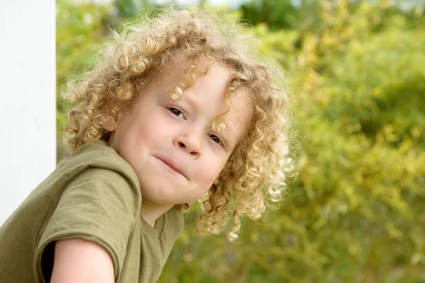 Porträtt av en ung pojke med blont lockigt hår — Stockfoto