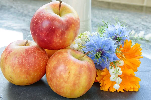 Äpfel mit einem Strauß Blumen — Stockfoto