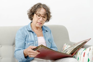 Fotoğraf albümü arayan orta yaşlı kadın