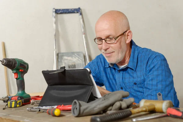 Man met de tablet in zijn atelier — Stockfoto