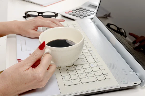 Mano de mujer con taza de café en el escritorio — Foto de Stock