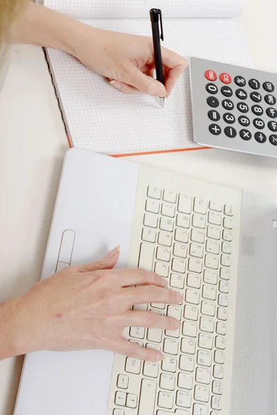 Mano della donna che scrive su carta sulla scrivania — Foto Stock