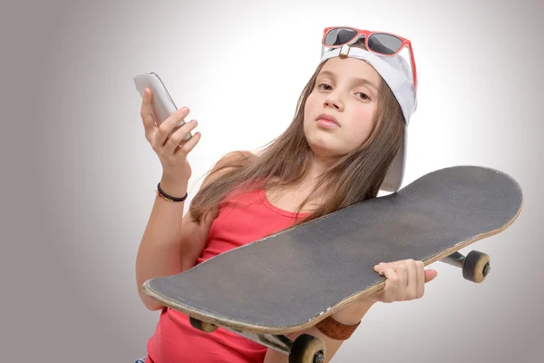 Tiener met een skateboard en een telefoon — Stockfoto