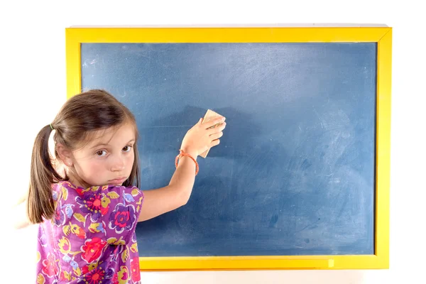 Schoolgirl erases on the blackboard — Stock Photo, Image