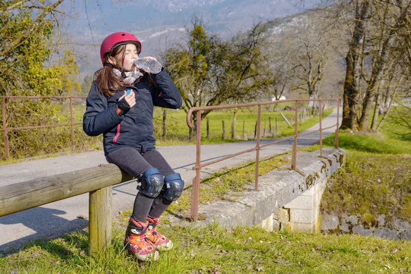 Preteen met roller skate helm, een water drinken — Stockfoto