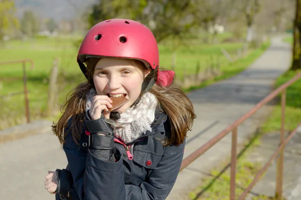 Preteen met roller skate helm, een taart te eten — Stockfoto