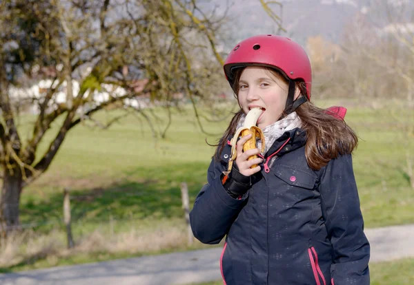 Preteen roller skate hjälm, äta banan — Stockfoto