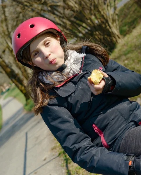 Preteen roller skate hjälm, äter ett äpple — Stockfoto