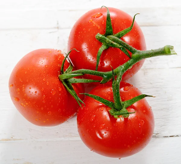 Tre tomater på vita träbord — Stockfoto