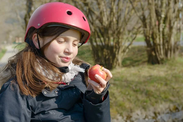 Nedospělý s kolečkové brusle helmu, jíst jablko — Stock fotografie