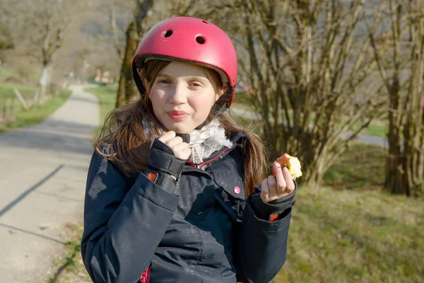 ローラー スケート ヘルメットとプレティーンがリンゴを食べる — ストック写真