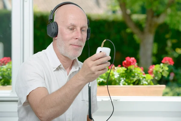 Mature homme écouter de la musique avec son téléphone — Photo