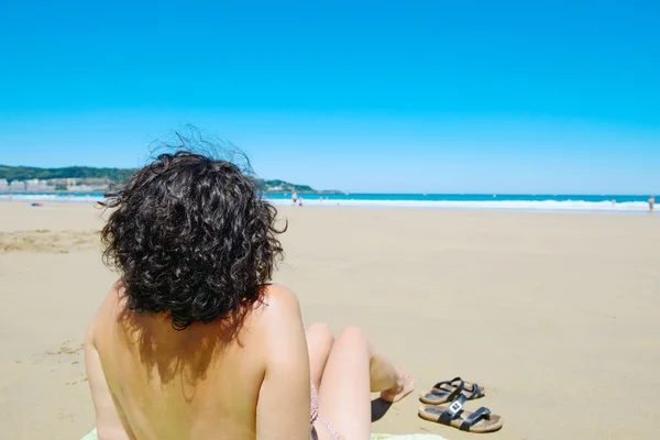 Frau mittleren Alters ruht sich am Strand am Meer aus — Stockfoto