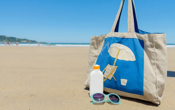 Sun lotion en zonnebrillen in het strand — Stockfoto
