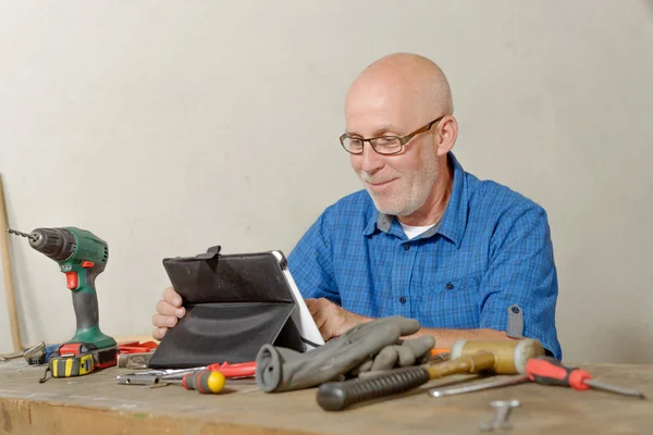 Man met de tablet in zijn atelier — Stockfoto