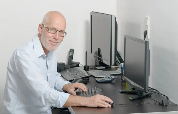 Reifer Mann arbeitet mit seinem Computer — Stockfoto