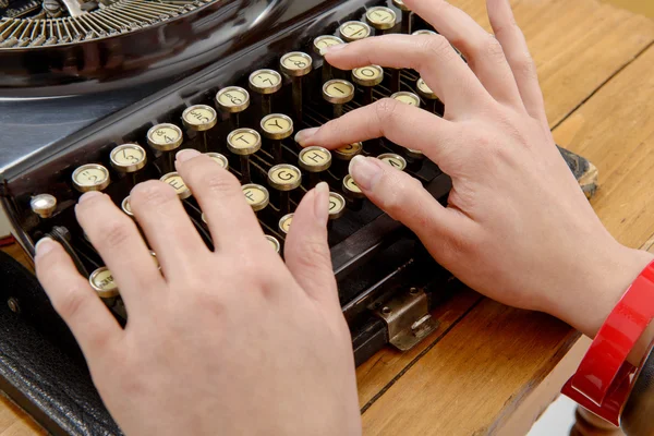 Mani di una giovane donna con una vecchia macchina da scrivere — Foto Stock