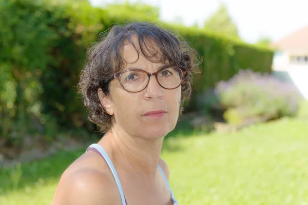 Mujer de mediana edad con gafas en el jardín —  Fotos de Stock