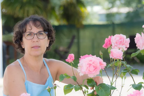 Μέσης ηλικίας γυναίκα με γυαλιά στον κήπο — Φωτογραφία Αρχείου