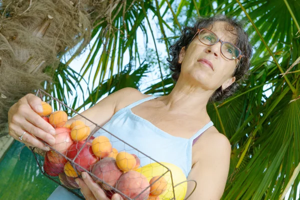 Femme avec un panier de fruits — Photo