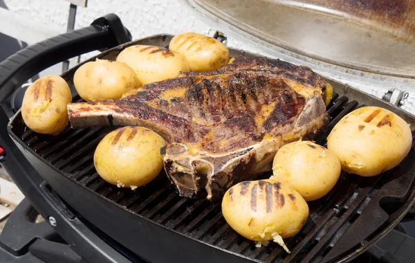 Costela de carne com batatas no churrasco — Fotografia de Stock