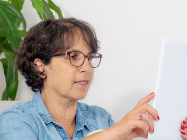 bir tablet ile olgun bir kadın portresi