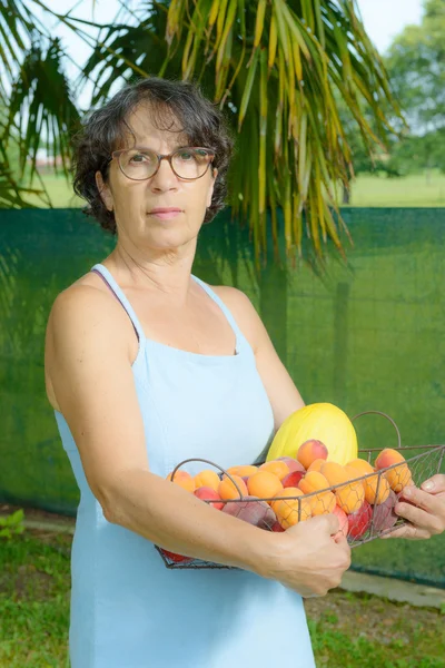 Зріла жінка з фруктовим кошиком — стокове фото