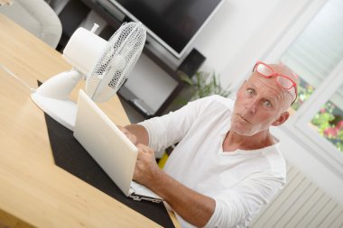 evde bir dizüstü bilgisayar ile olgun adam