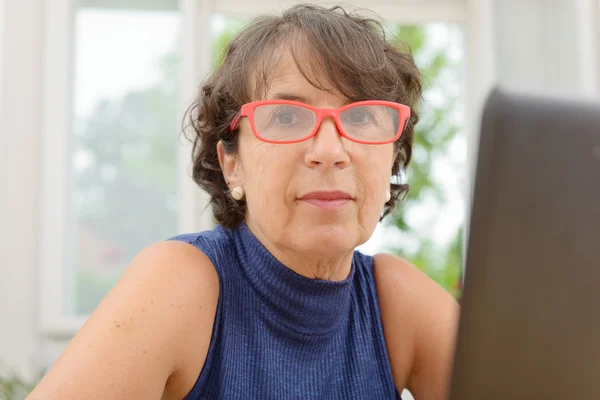 Portrait of a beautiful mature woman with red glasses — Stock Photo, Image
