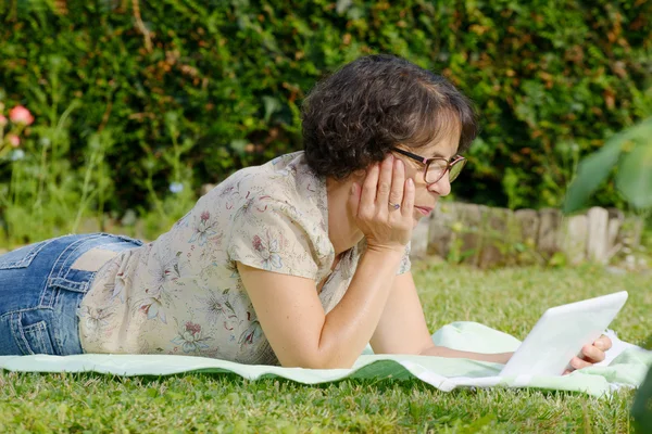 Mujer madura está descansando en el jardín — Foto de Stock