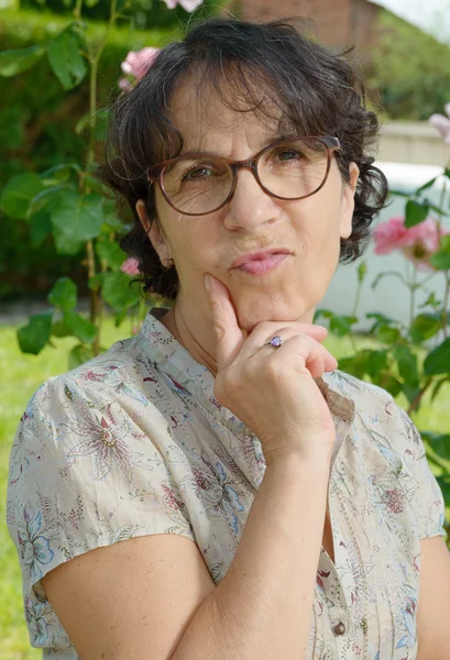 Mujer de mediana edad con gafas en el jardín — Foto de Stock