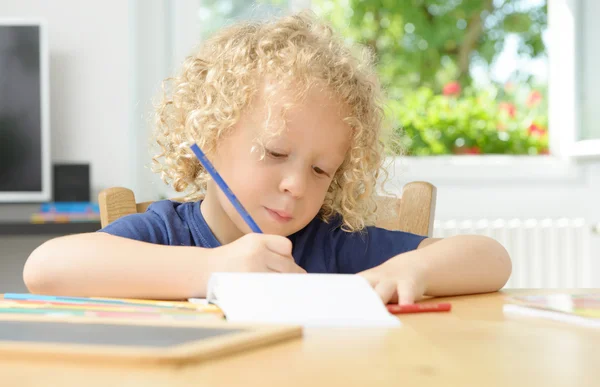 Kleiner blonder Junge zeichnet in seinem Haus — Stockfoto