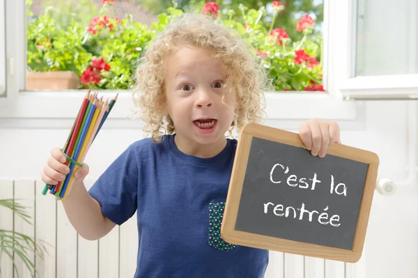 Garçon tenant une ardoise écrite de retour à l'école — Photo