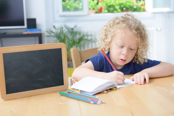 Menino desenho em um caderno — Fotografia de Stock