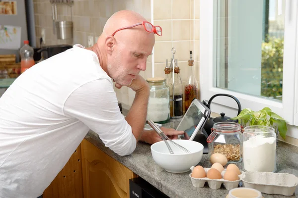 Senior man in kitchen using  tablet — Stock Photo, Image