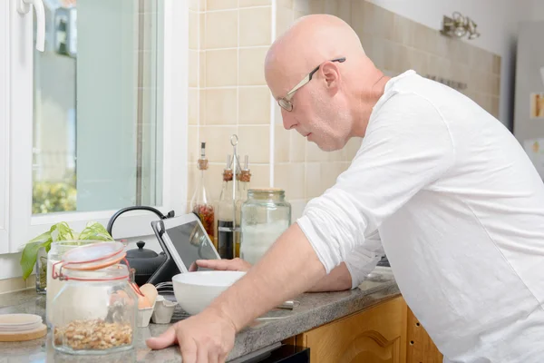 Senior man in kitchen using  tablet — Stock Photo, Image