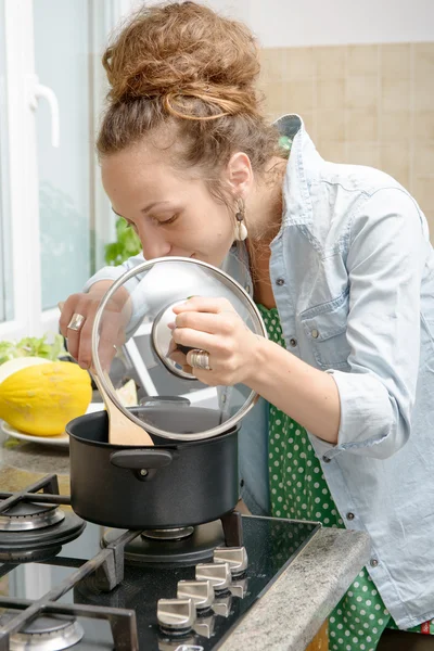 Young woman cooking dinner in the kitchen — Stock Photo, Image