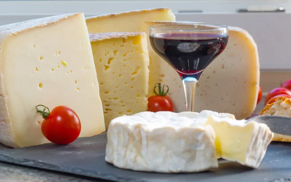 Διάφορα Γαλλικά τυριά με ποτήρι κόκκινο κρασί — Φωτογραφία Αρχείου