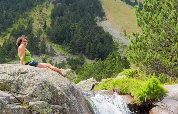 ハイカーの女性が山で岩の上にかかっています。 — ストック写真