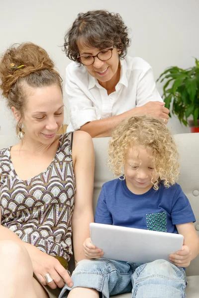 Dítě a jeho matka s babičkou hrají s tabletem — Stock fotografie
