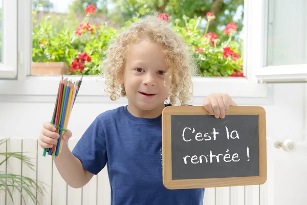 Garçon tenant une ardoise écrite de retour à l'école — Photo