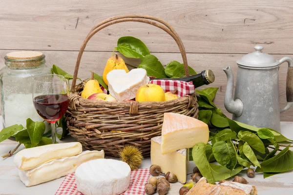 Queijos franceses com uma cesta de frutas — Fotografia de Stock